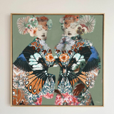 Framed artwork of a woman with butterfly wings and floral headpieces on a light background