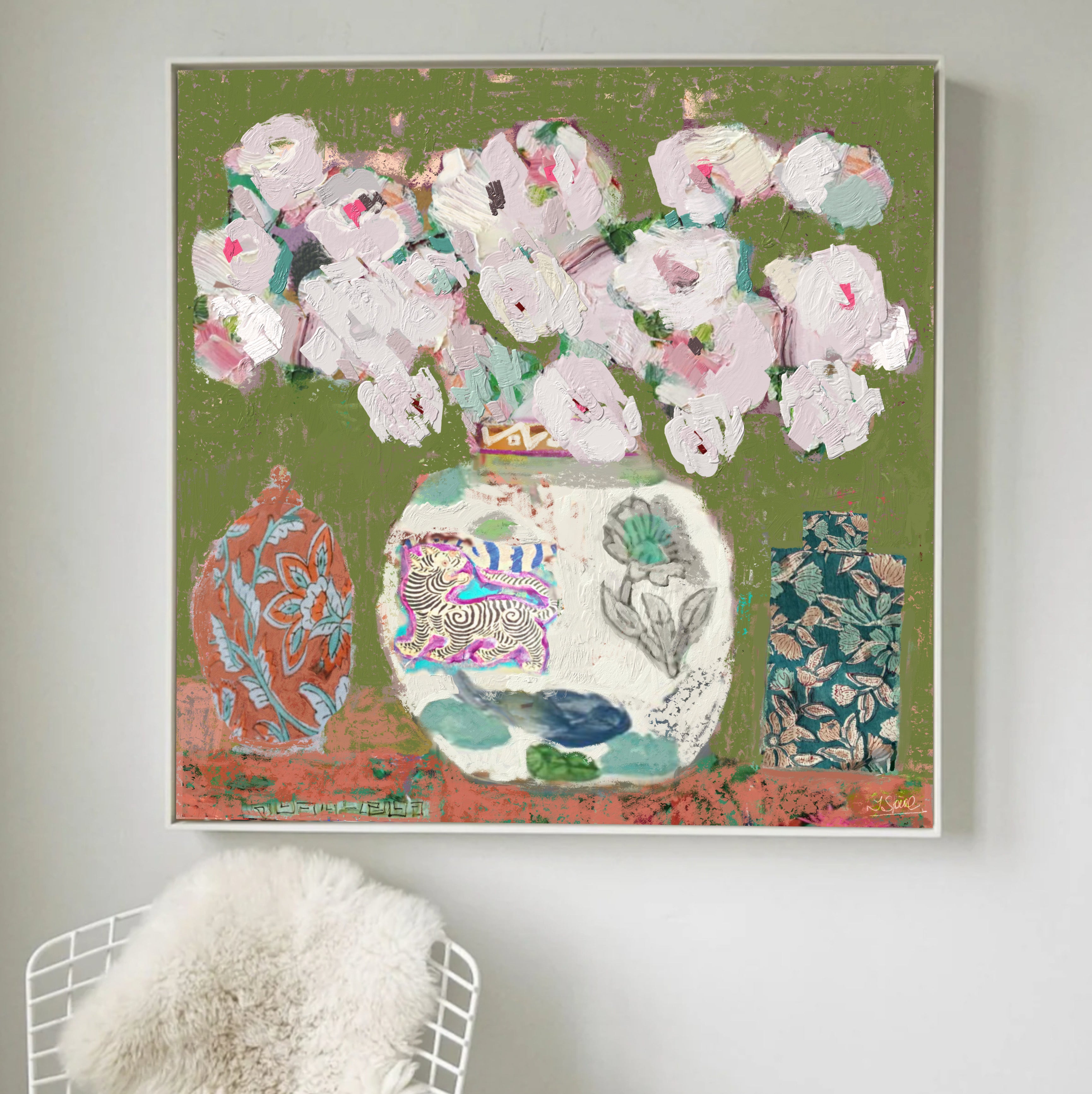 A square framed canvas print featuring an abstract still life painting of white roses in chinoiserie ginger jar vases against an olive green background, hung on a light gray wall above a white wire chair with a fluffy white throw.