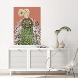 Framed artwork of a woman with floral headpiece on a wall above a white cabinet.