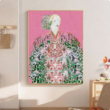 Framed artwork of a person in traditional attire on a pink background, displayed in a room.