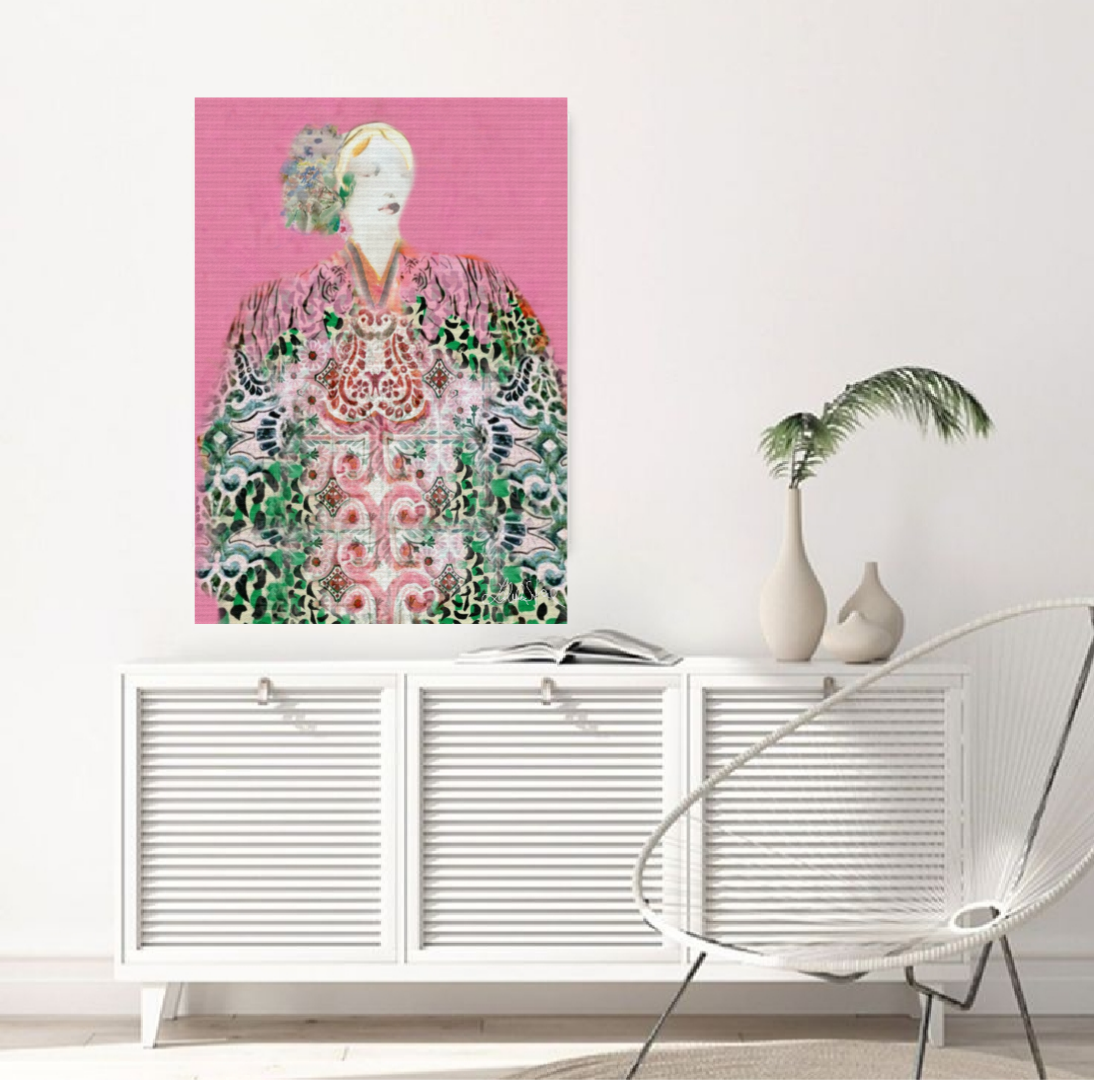 Framed artwork of  green and pink boho woman with floral hair on a pink background, displayed above a white cabinet in a room.