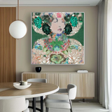 A large framed wall art print featuring an abstract floral portrait with green, pink, cream, and dark accents, displayed above a light wood sideboard in a modern dining room setting.